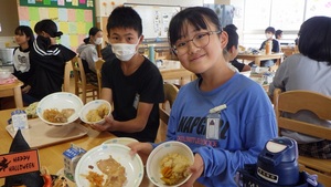 子どもたちが給食のお椀を持っている様子