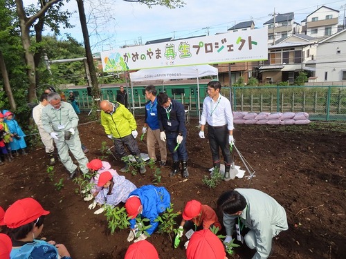 子どもたちとともに植樹をする市長