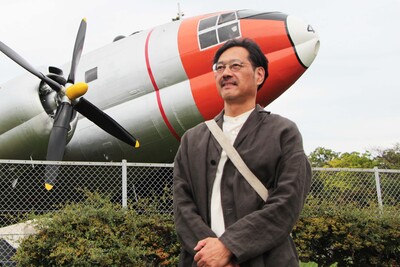 航空記念公園の飛行機の前に立つ岡田さん