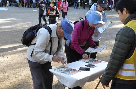 スタンプラリーの台紙にスタンプを押す参加者の様子