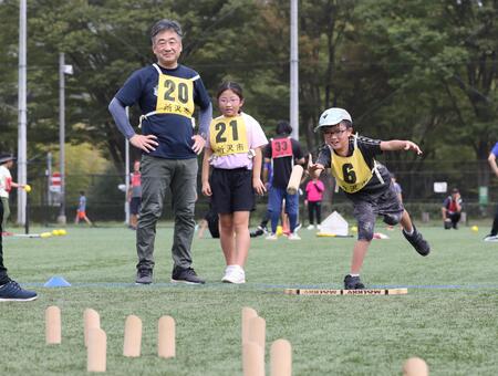 スキットルに向かってモルックを投げている少年の様子