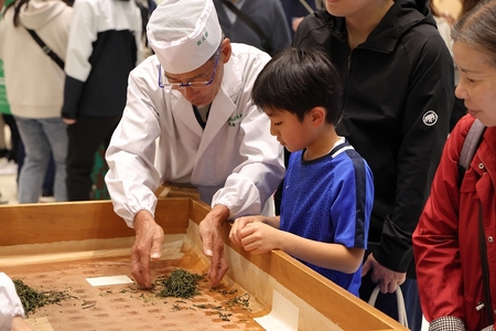 お茶農家さんがお手本で手もみ作業をしている画像