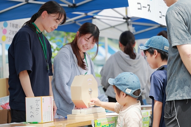 ガラポンを回す男の子とそれを見守る家族と受付の人