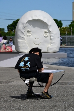 目の前の造形物を描写する男の子
