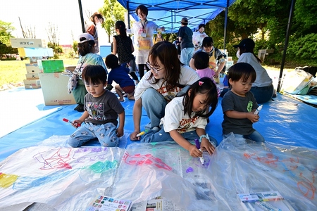 母とこども3人で絵を描いている様子