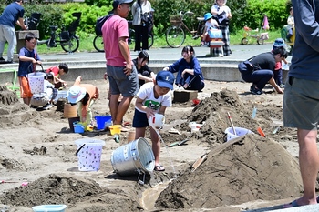 砂場で水を流している男の子