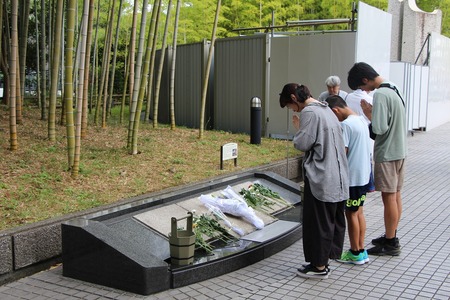 敷石の前で祈る親子