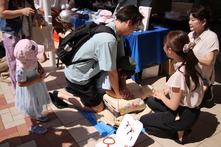 人体モデルに心臓マッサージをする父子